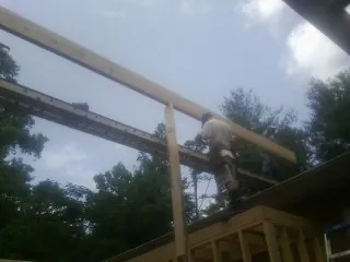 Carpenter setting a ridge beam over a new addition frame — Ice Dam Removal by Roofing Brothers in West Hyannisport
