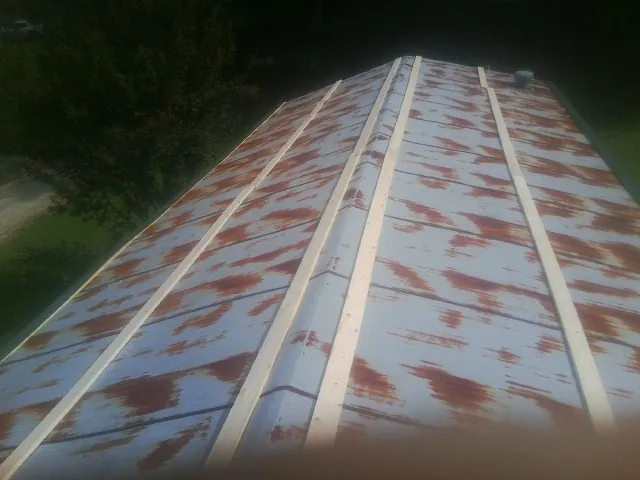 Rusted metal roof panels with new wood purlins before replacement — Storm Damage Roof Repair in West Hyannisport by Roofing Brothers