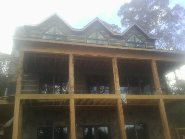 Dormers and porch framing on a large log home under construction — Roof Coating work by our crew in West Hyannisport