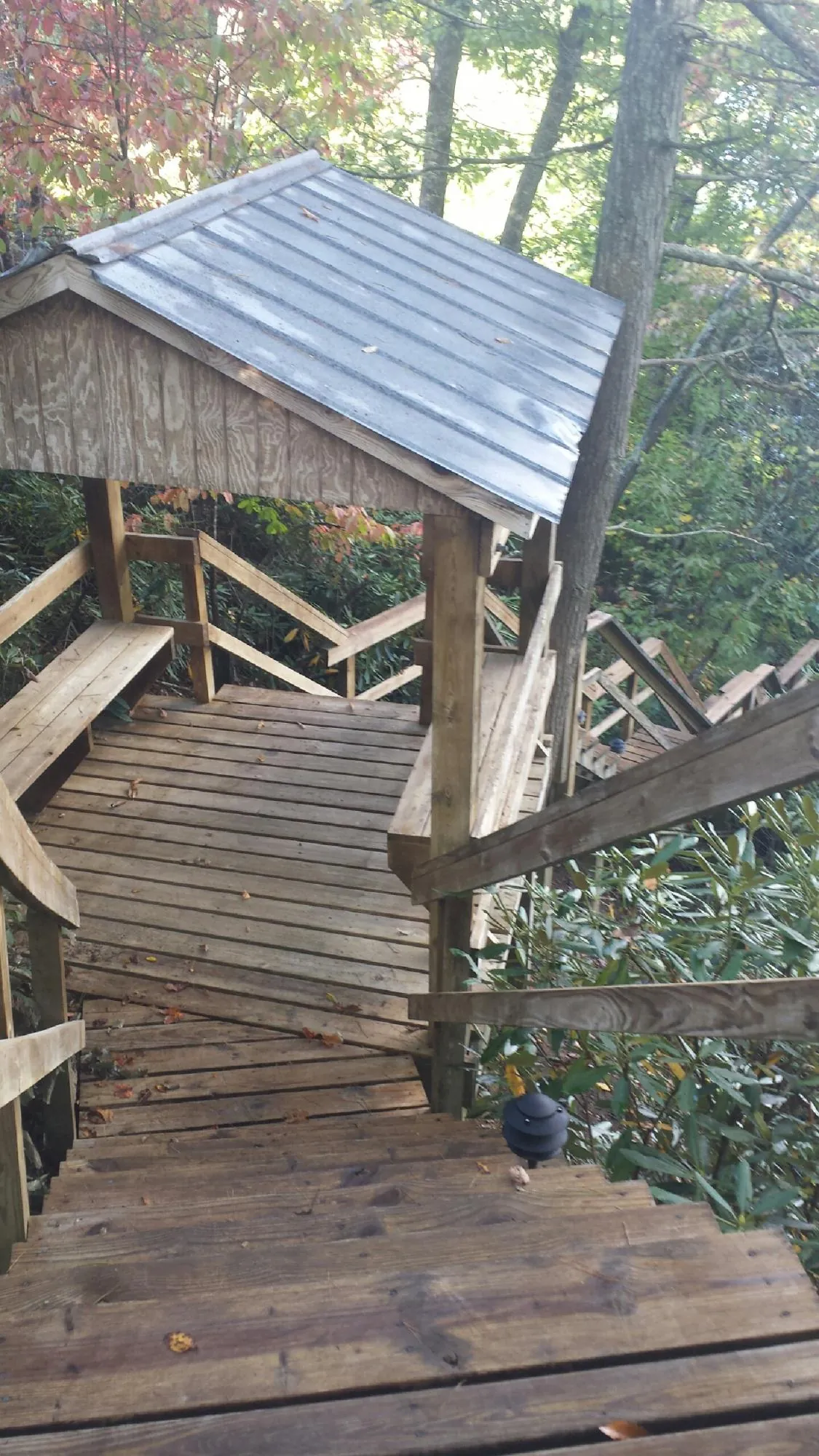 Metal roofed shelter over wooden steps on a wooded walkway — Skylight Repair & Installation work by our crew in West Hyannisport
