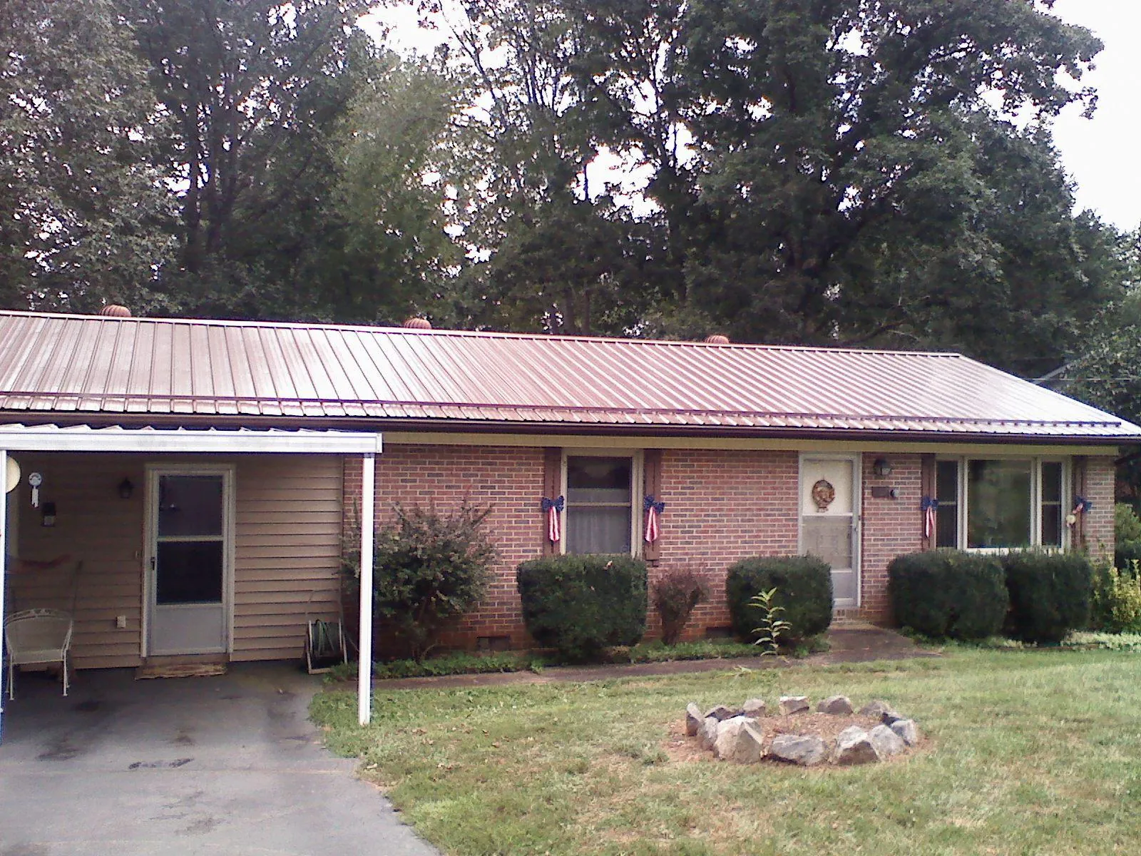 Bronze metal roof and carport on a brick ranch home — Roof Repair work by our crew in West Hyannisport